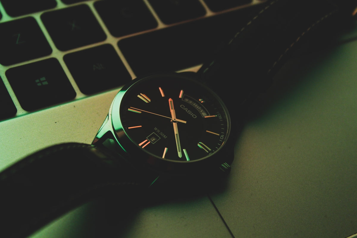 a watch sitting on top of a laptop computer